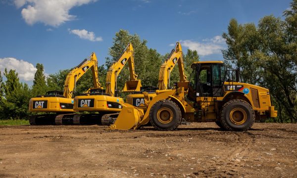 Four yellow excavators at an outdoor construction site in Kyiv, Ukraine.